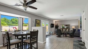 A spacious living area with a dining table, chairs, a sofa, and a television. - Desert Retreat with Private Pool & Spa | Near Downtown Palm Springs (Palm Springs)