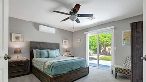 A bedroom with a bed, bedside tables, a ceiling fan, and a view through a sliding glass door. - Desert Retreat with Private Pool & Spa | Near Downtown Palm Springs (Palm Springs)