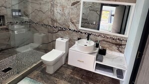 A bathroom with a glass-enclosed shower, a toilet, a sink, and a mirror. - Paradise found on Costa Azul, sleeps 12 in 5 bedrooms. One minute to the beach (Acajutla)