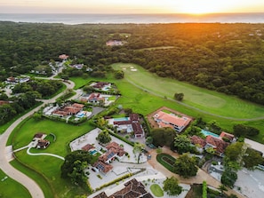 A residential area with houses, a golf course, and a body of water. - 4-Bedroom House with Pool at Hacienda Pinilla (Pinilla)