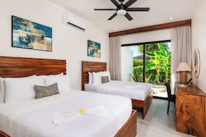 A hotel room with two beds, a ceiling fan, air conditioning, a large window with curtains, and artwork on the walls. - 4-Bedroom House with Pool at Hacienda Pinilla (Pinilla)