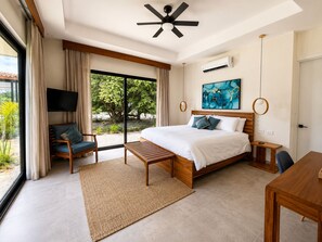 Une chambre moderne avec un grand lit, un bureau, une chaise et un téléviseur.