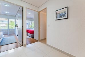 Ein Hotelzimmer mit Balkon, einem Bett, einem roten Sofa und einem gerahmten Bild an der Wand.