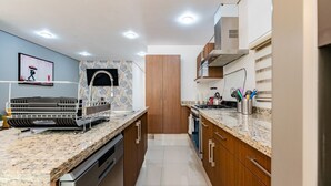 Eine moderne Küche mit Granitarbeitsplatten, Edelstahlgeräten und Holzschränken.