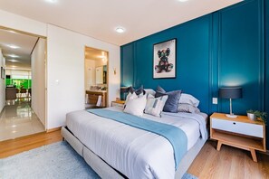 A modern bedroom with a large bed, a bedside table with a lamp, and a wall-mounted artwork. - Stylish 3BR Stay • Roma Norte, Balcony & Workspace (Ciudad de México)