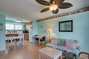 Ein kompakter Wohnraum mit Küchenzeile, Essbereich und Sofa.