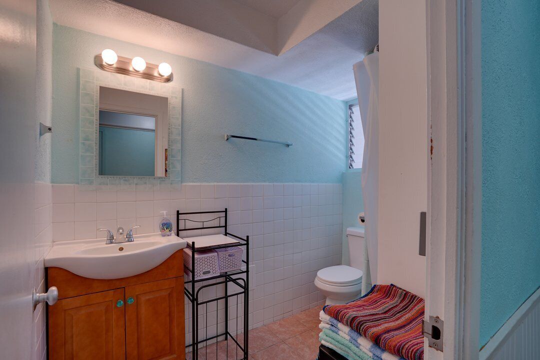 A bathroom with a sink, mirror, and vanity.