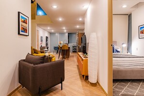 Ein modernes Wohnzimmer mit einer Couch, einem Essbereich und einer Küche im Hintergrund.
