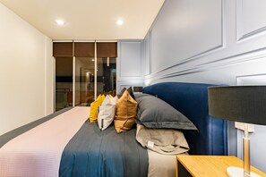 A hotel room with a bed, pillows, a bedside table, and a lamp. - 3BR Roma Norte Penthouse w/ Private Rooftop (Ciudad de México)