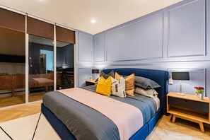 A modern bedroom with a large bed, a nightstand, a lamp, and a sliding glass door leading to a bathroom. - 3BR Roma Norte Penthouse w/ Private Rooftop (Ciudad de México)