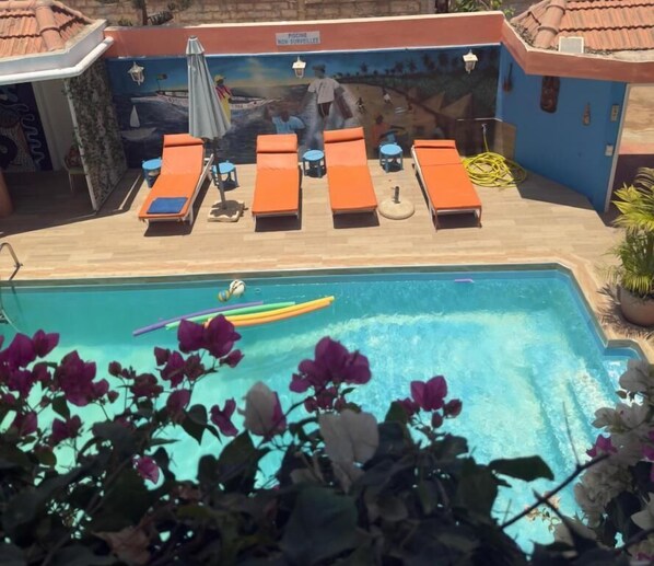 A pool area with lounge chairs and a mural.