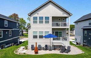 A two-story residential building with a balcony, outdoor seating area, and a fire pit. - Blue Haven | 5 min walk to beach • pool • grill (South Haven)