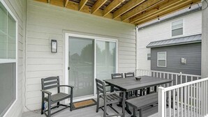 En inglasad veranda med ett bord och stolar, en bänk och en skjutdörr i glas.