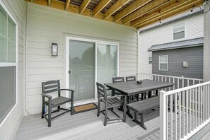 A covered deck with a table and chairs, a bench, and a sliding glass door. - Haven House | 5 min walk to beach • pool • grill (South Haven)