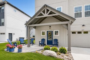 A residential building with a covered porch, multiple windows, and a garage. - Blue Haven | 5 min walk to beach • pool • grill (South Haven)