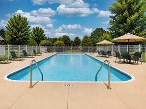 A rectangular swimming pool with a white deck, surrounded by a white fence, and equipped with two metal ladders. - Blue Haven | 5 min walk to beach • pool • grill (South Haven)