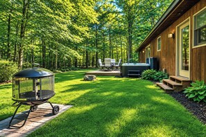 A wooden cabin with a deck, outdoor seating, and a hot tub. - Wildhaus Retreat | Hot Tub • Private Walking Trail (South Haven)
