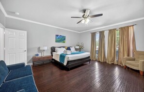 A bedroom with a bed, a desk, a chair, and a ceiling fan. - All Ensuites Retreat near Lake & Airport – Pool (Lewisville)