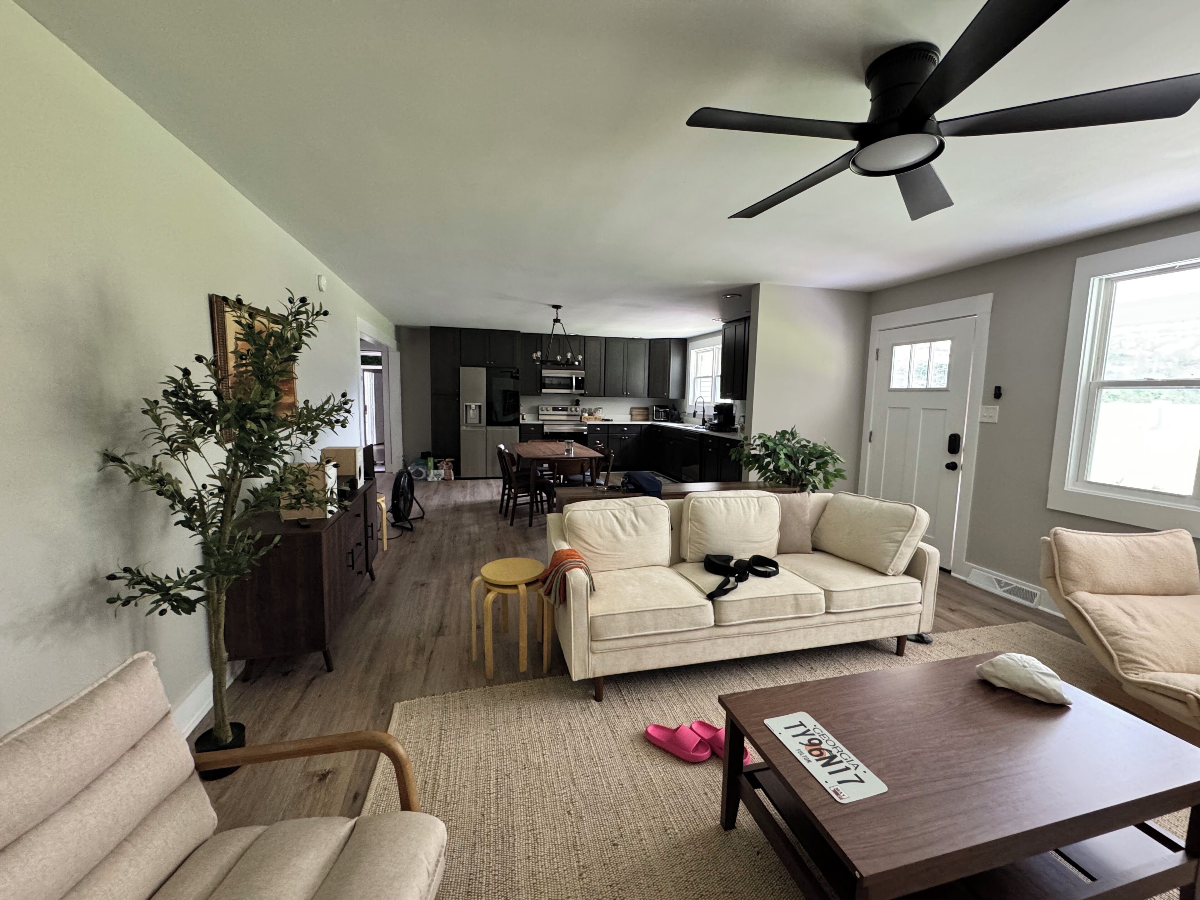 A living room with a sofa, a coffee table, and a ceiling fan.