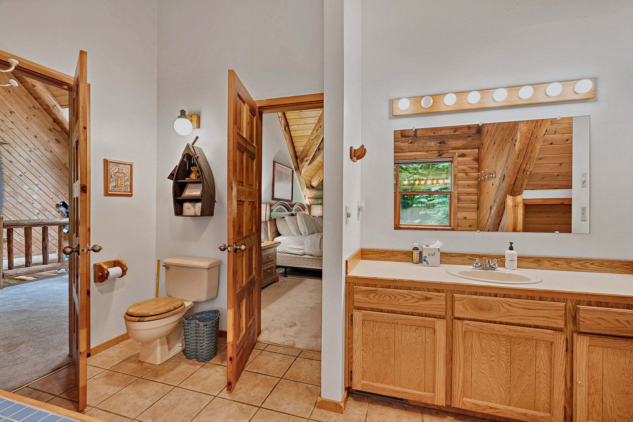Een badkamer met een houten wastafelmeubel, toilet en douche.