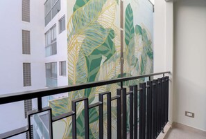 A balcony with a railing and a view of a building with large windows. - w* | Designer 2BR Stay w/ Balcony in Miraflores (Lima)