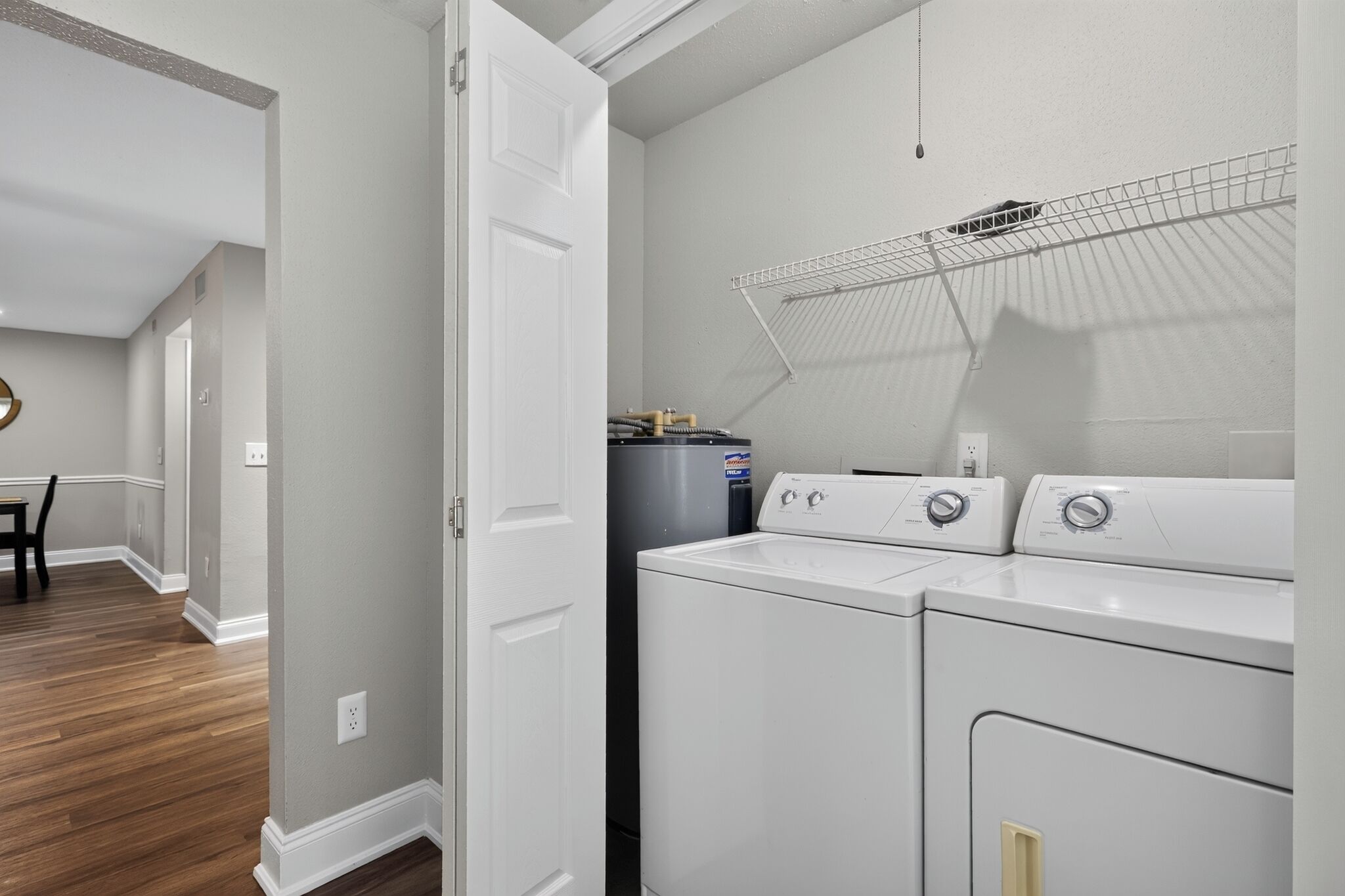 A laundry room with a washing machine, dryer, and a water heater.