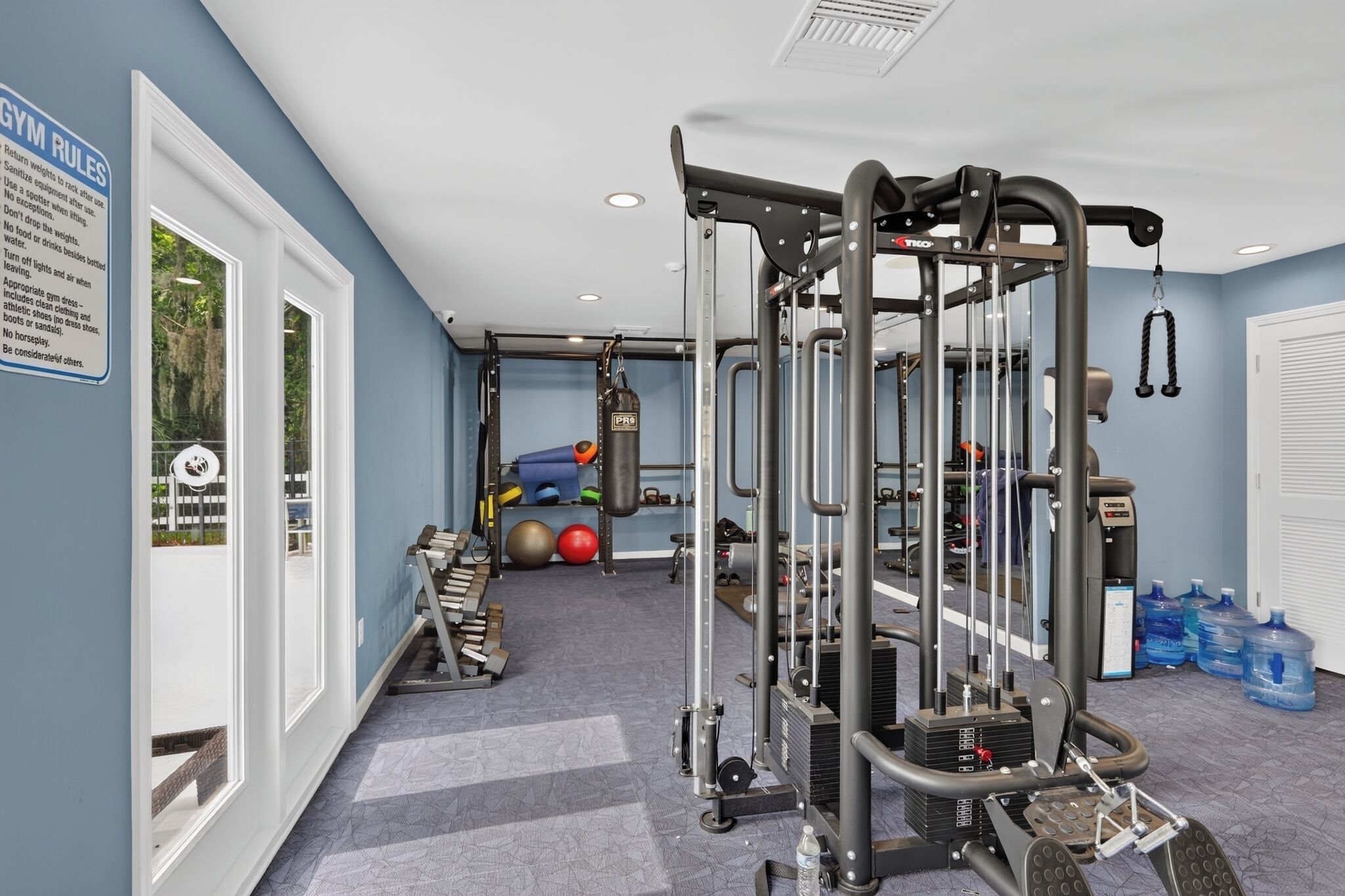 Une salle de sport équipée de matériel d’exercice, d’un sac de frappe et de bouteilles d’eau.