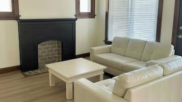 Un salon avec une cheminée, un canapé et une table basse.