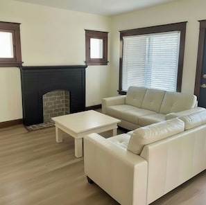 A living room with a fireplace, a sofa, and a coffee table. - Pet Friendly home, modern updates, minutes from Airport (St. Louis)