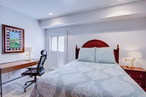 A bedroom with a bed, desk, chair, and nightstands. - Historic Charleston Right Outside Your Front Door (Charleston)