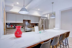 A modern kitchen with white cabinets, stainless steel appliances, and a marble countertop. - Historic Charleston Right Outside Your Front Door (Charleston)