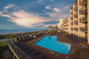 Ein Hotelpool mit Blick auf Strand und Meer.