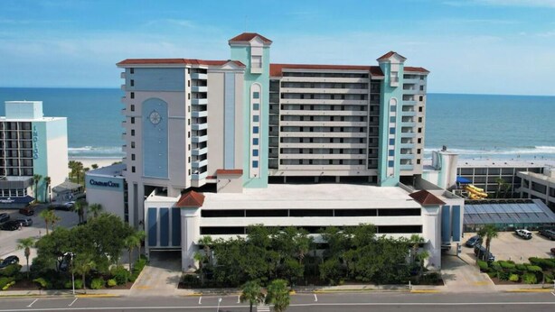 Un hotel de varios pisos con un atrio central, una torre de reloj y vistas al océano.