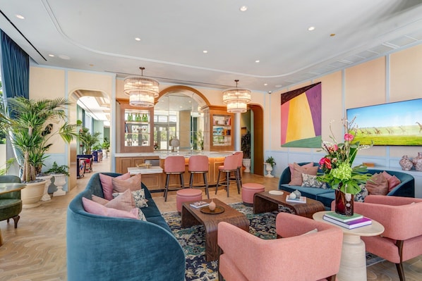 A spacious living area with a bar, comfortable seating, and a large TV. - Luxury NoMad Wynwood Miami Art & Style (Miami)