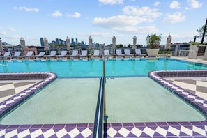 A rooftop pool with a city skyline view, lounge chairs, and a tiled deck. - Luxury NoMad Wynwood Miami Art & Style (Miami)