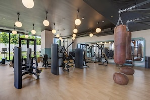 A gym with various exercise equipment, including weight machines and a punching bag. - Luxury NoMad Wynwood Miami Art & Style (Miami)