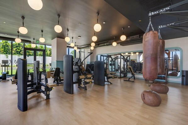 Ein Fitnessstudio mit verschiedenen Trainingsgeräten, darunter Kraftgeräte und ein Sandsack.