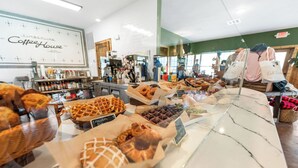 Une vitrine de boulangerie présentant diverses pâtisseries, avec une enseigne de café en arrière-plan.