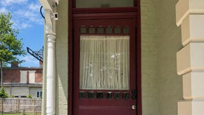 A red door with a glass panel and a white picket fence. - A Grand Historic Retreat-Downtown Covington-Sleeps 3 (Covington)