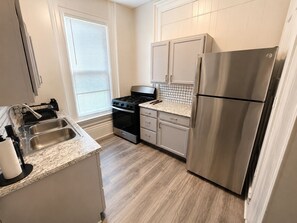 A kitchen with a stainless steel refrigerator, a gas stove, and a sink. - A Grand Historic Retreat-Downtown Covington-Sleeps 3 (Covington)