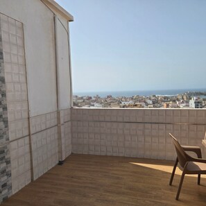 Un balcón con vista a un paisaje urbano y al mar.