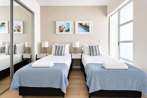 Ein Hotelzimmer mit zwei Betten, einem großen Spiegel und Bildern an der Wand.