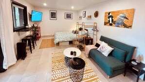 Una sala de estar moderna con un sofá, una mesa de centro, un televisor y obras de arte en las paredes.