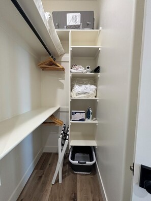 A storage closet with shelves, a hanging rack, and a laundry basket. - RollingTetonRetreat_Hot tub_Sauna_Patio_FamilyFriendly (Tetonia)