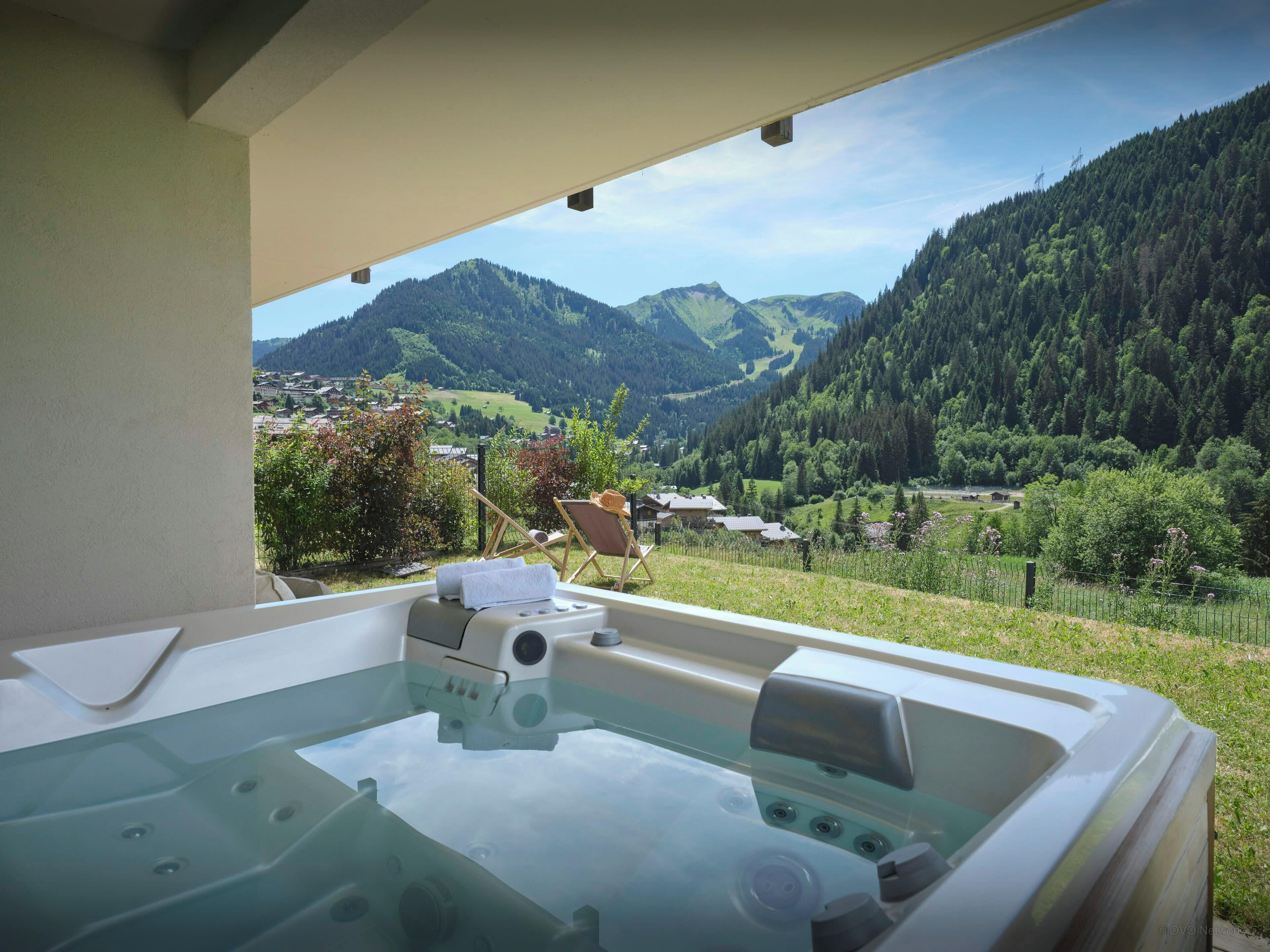 A hot tub with a view of a mountainous landscape.