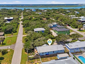 An aerial view of a residential area with houses, a road, and a body of water in the background. - 1 Block to Beach | New Outdoor Living Space (St Augustine)