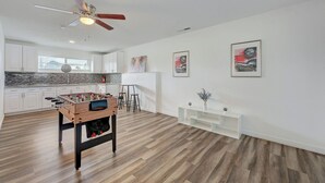 A modern kitchen with white cabinets, a foosball table, and a ceiling fan. - Spacious Vegas Retreat • Close to Strip • Sleep 12 (Las Vegas)