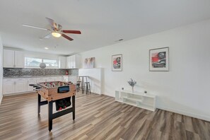 A modern kitchen with white cabinets, a foosball table, and a ceiling fan. - Spacious Vegas Retreat • Close to Strip • Sleep 12 (Las Vegas)