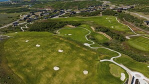 A golf course with multiple holes, a residential area with houses, and a mountainous backdrop. - NEW Luxury Retreat in Deer Valley East, Free Ski Shuttle, Hot Tub, Sleeps 18 (Heber City)