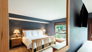 Ein Schlafzimmer mit einem Bett, zwei Nachttischen, einer Fensterbank und einer Holzbank.